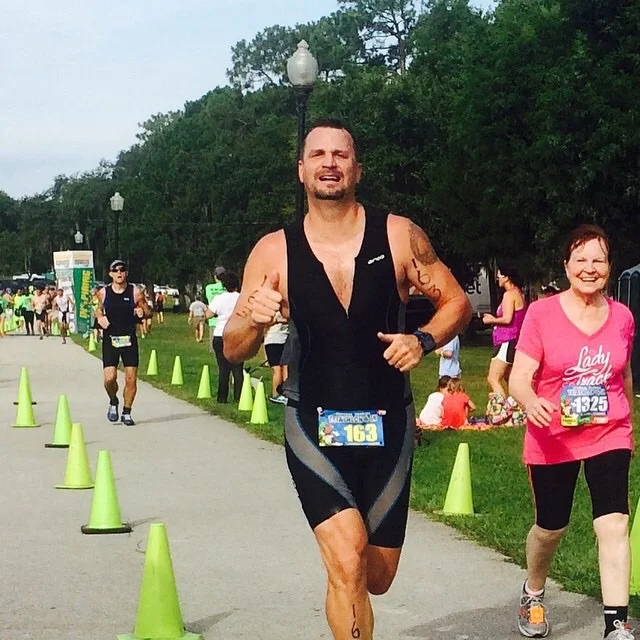 jandJ client crossing the finish line of a triathlon